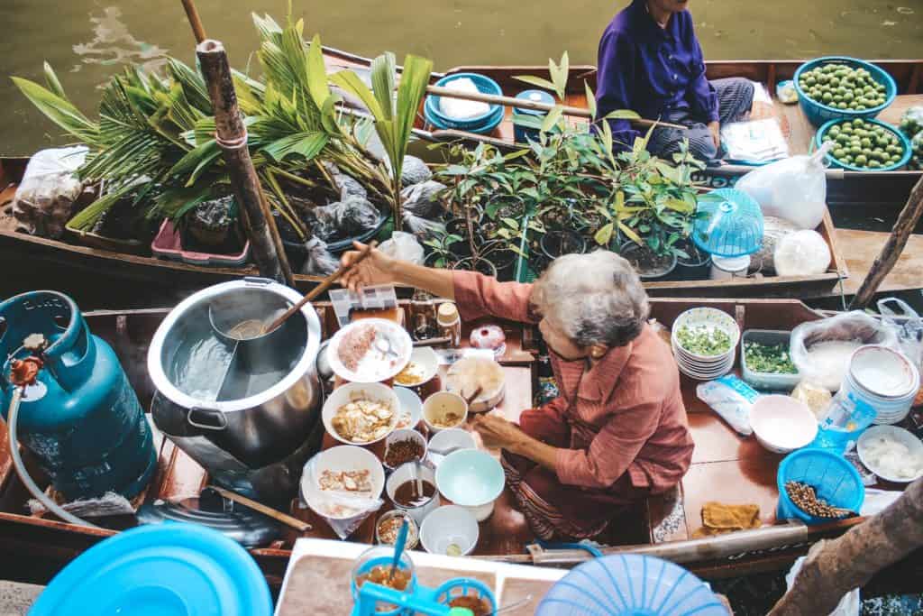 This lady has been selling noodles from her boat for over 50 years... everyday she has a super long line of people waiting for her famous noodles. The floating market in Thailand is an entire market on the waterway and the vendors are each on their little boats. Tour of the Railway Market and Floating Market from Bangkok, Thailand. #bangkok #thailand #railwaymarket #floatingmarket