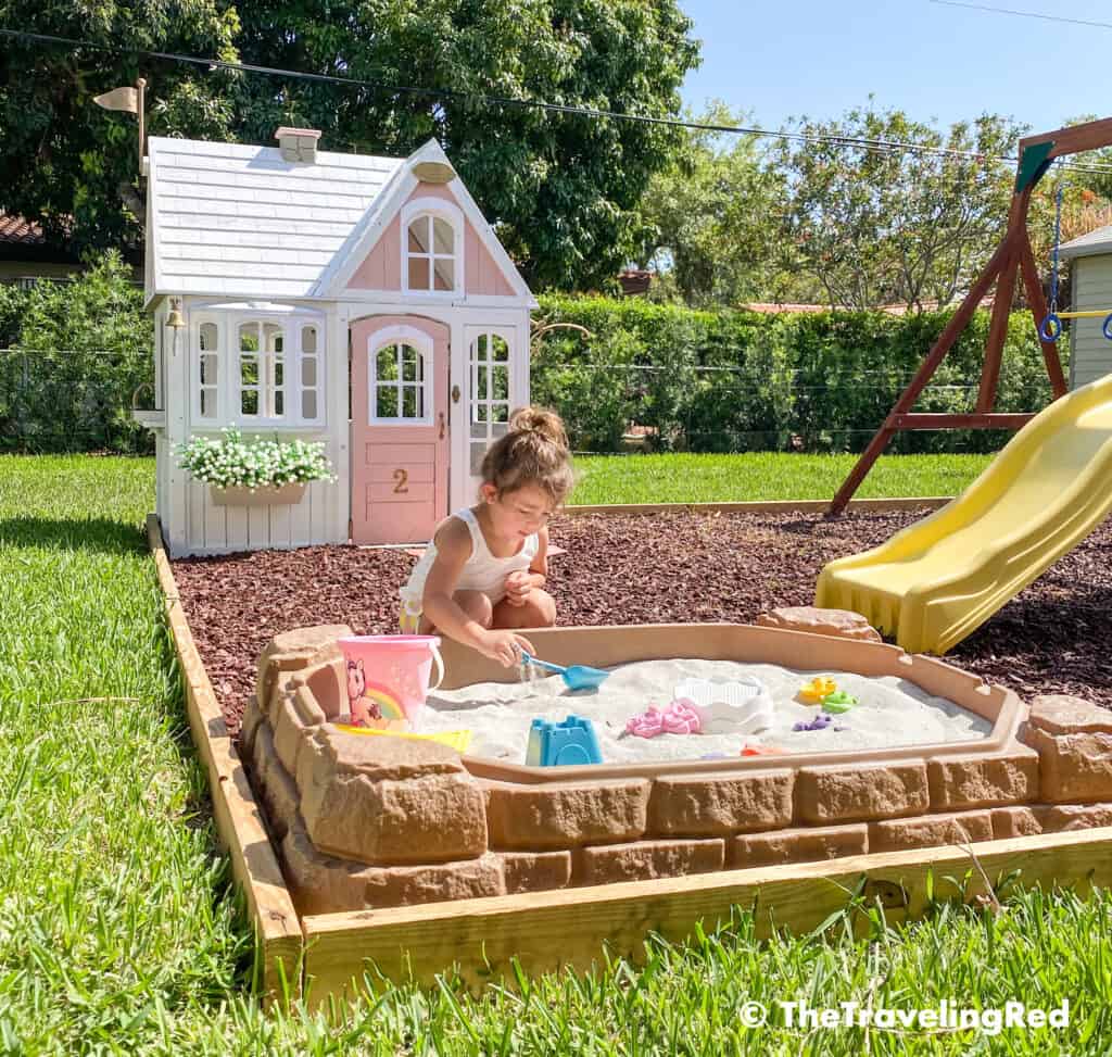 How we built a custom backyard playground with rubber mulch for our swingset, playhouse and sand box. Perfect little outdoor play space for your kids and it's soft on the feet.