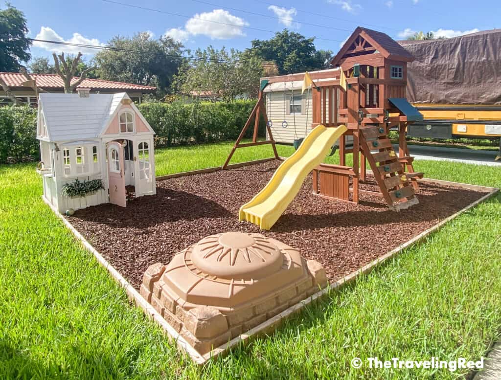 How to build a custom backyard playground with rubber mulch. Our completed space for our swingset, playhouse, sandbox or you can add any other outdoor toys you like. Perfect little outdoor play space for your kids to enjoy playing outside.