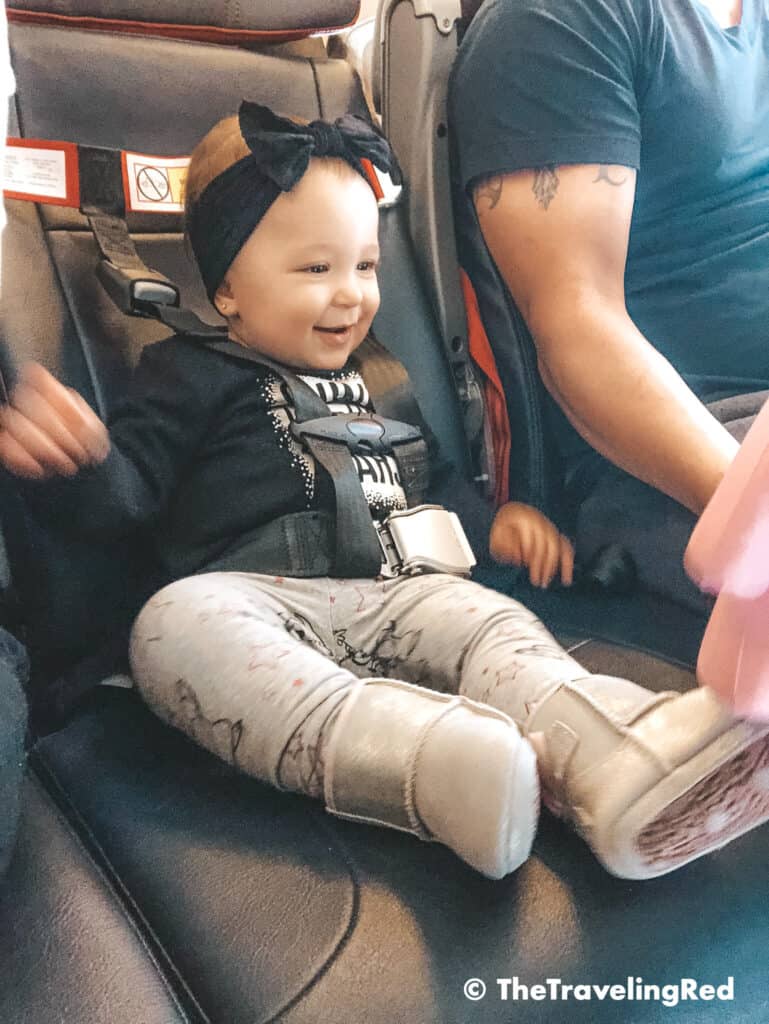 FAA approved airplane harness as an alternative to installing a car seat on an airplane. It it small and fits in your purse. The harness works with the airplane lap belt to restrain similar to a car seat. It does not affect the person sitting behind you because it goes under their tray table.