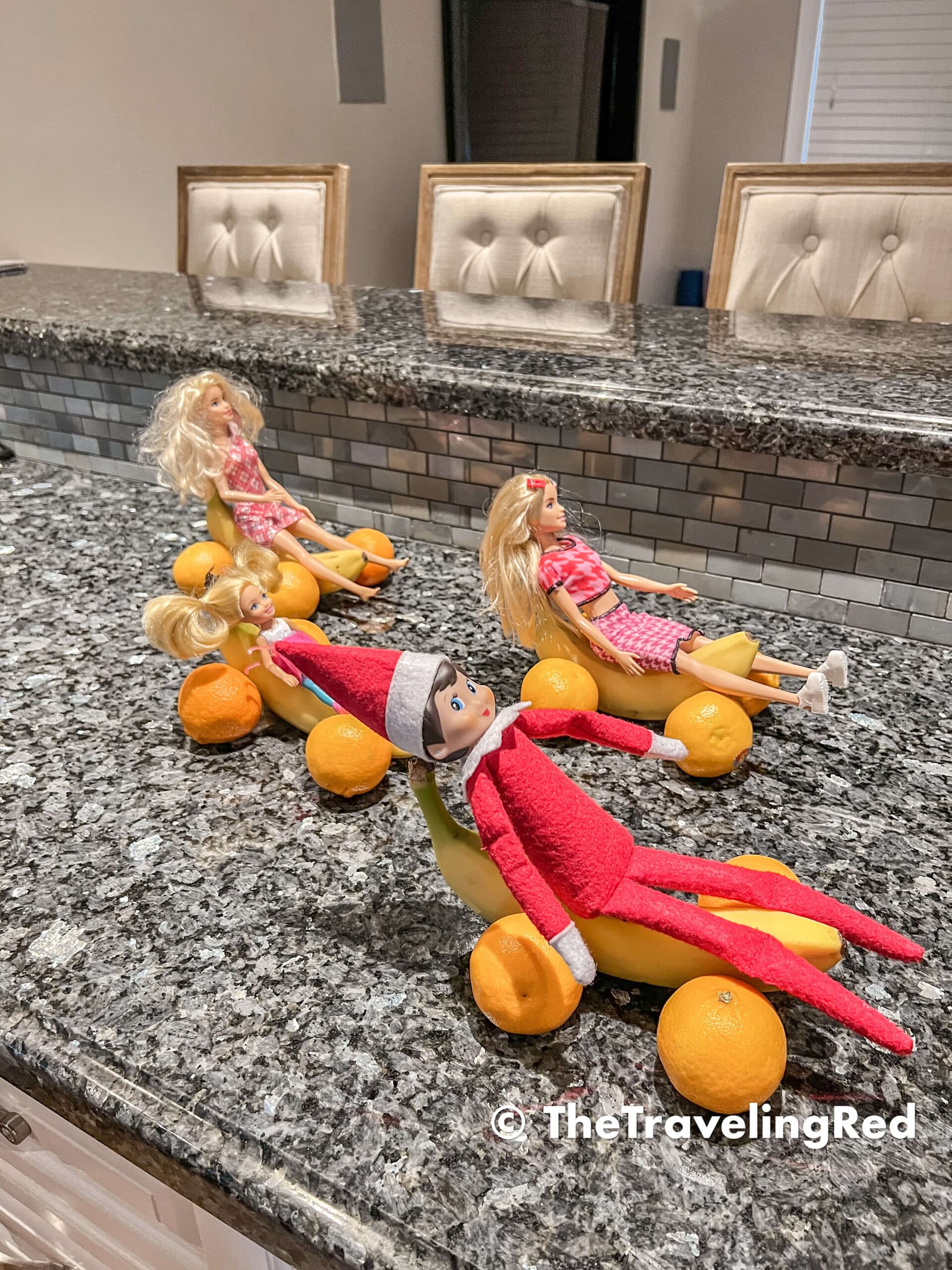 Naughty Elf on the shelf turned bananas and oranges into cars so she could have a race with her Barbie friends. Fun and easy elf on the shelf ideas for a naughty elf that are quick and easy using things you have at home.
