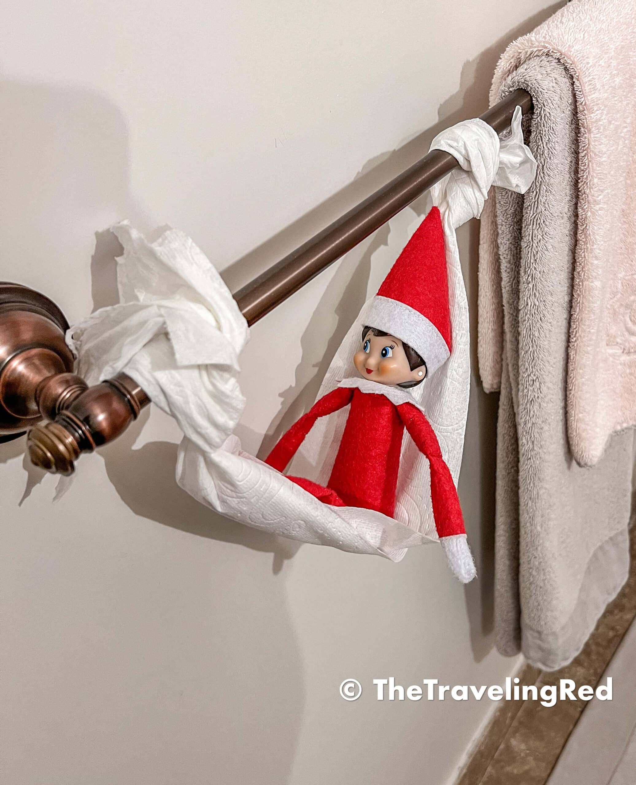 Naughty Elf on the shelf made a hammock out of toilet paper and hung from the towel bar in the bathroom. Fun and easy elf on the shelf ideas for a naughty elf that are quick and easy using things you have at home.