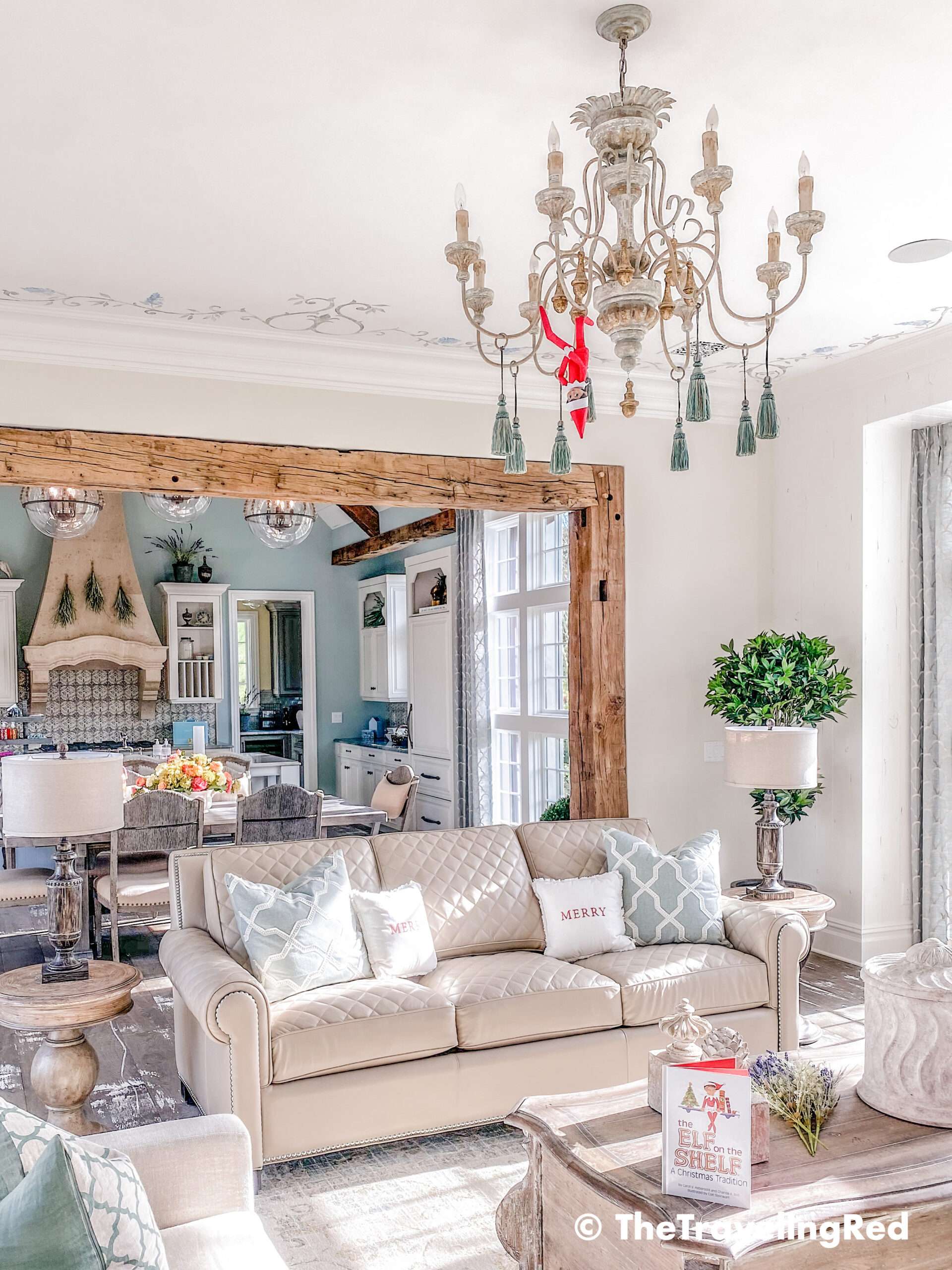 Naughty Elf on the shelf hanging upside down from the chandelier. Fun and easy elf on the shelf ideas for a naughty elf that are quick and easy using things you have at home.