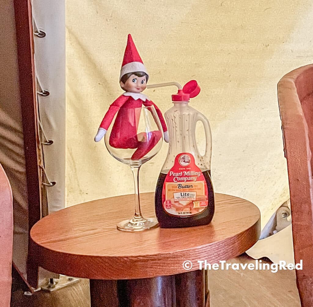 Naughty Elf on the shelf drank maple syrup out of the bottle from a straw. Fun and easy elf on the shelf ideas for a naughty elf that are quick and easy using things you have at home.
