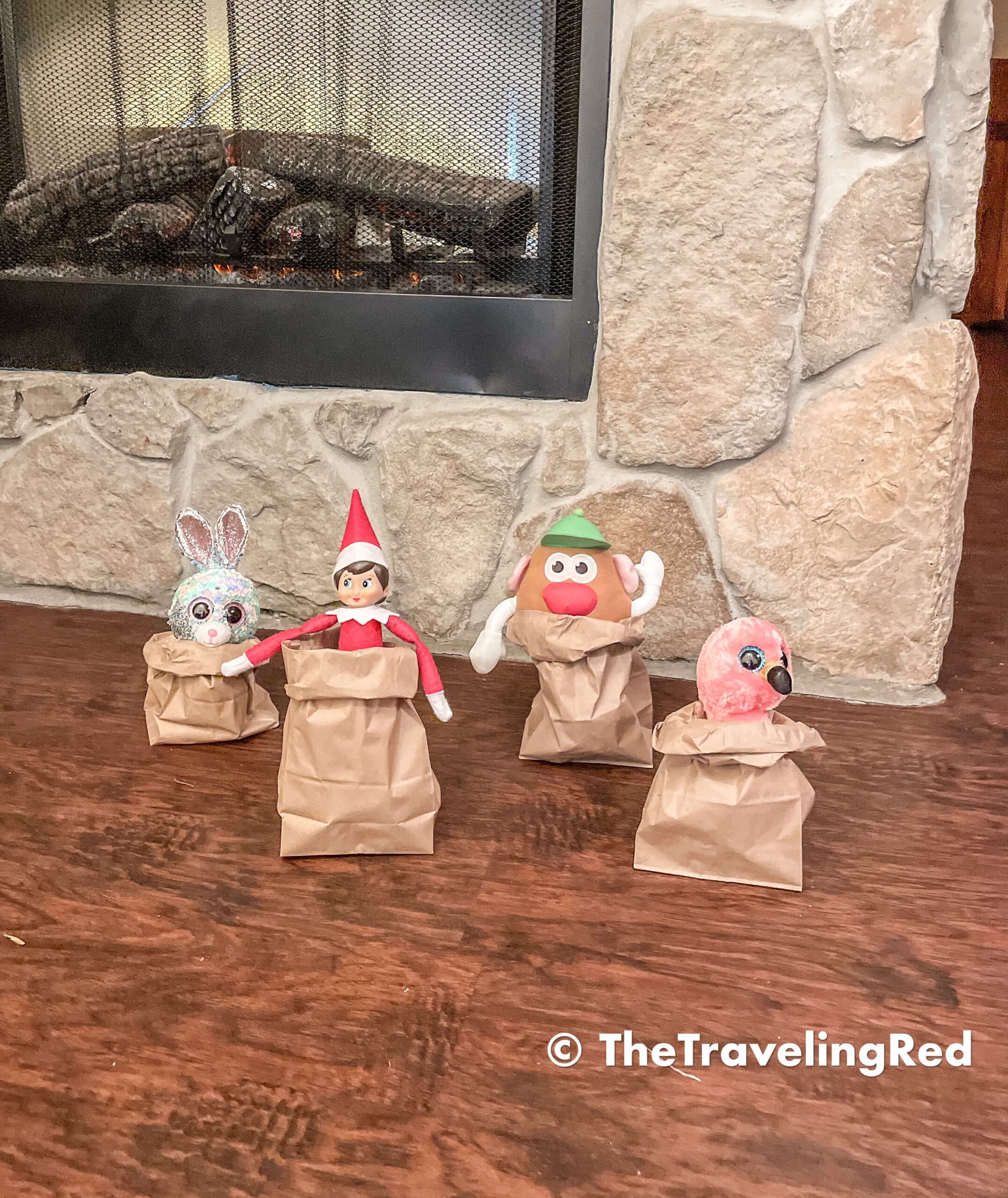Naughty Elf on the shelf playing with some friends. They used brown paper bags for a potato sack race. Fun and easy elf on the shelf ideas for a naughty elf that are quick and easy using things you have at home.
