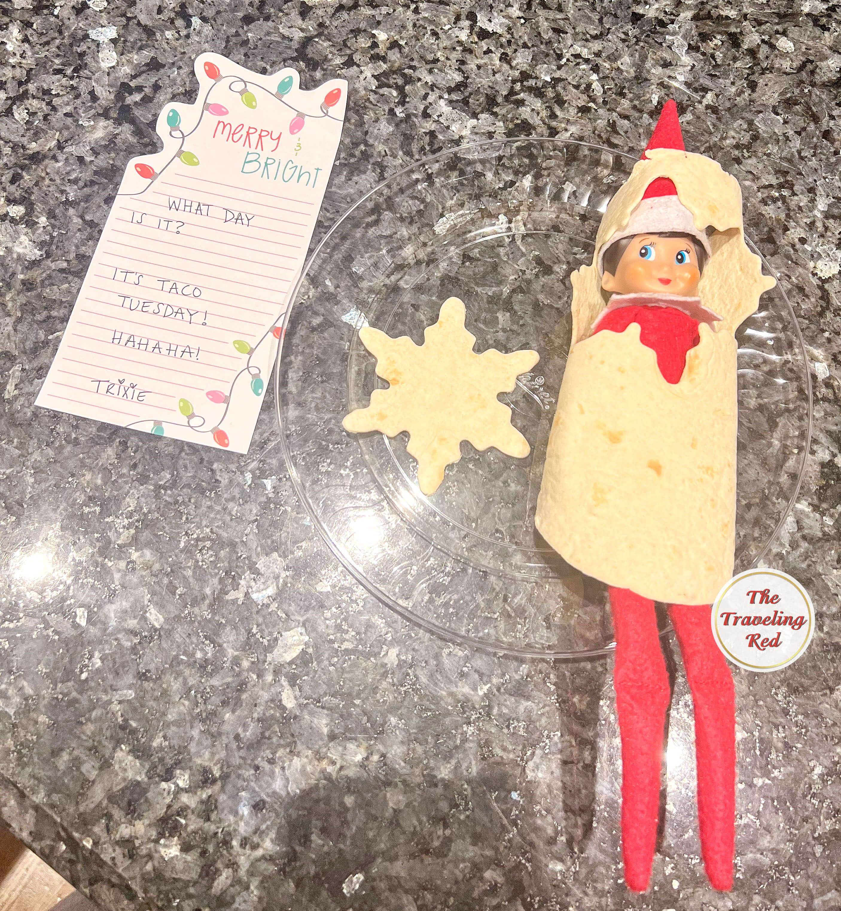 Elf on the Shelf Ideas: Elf is wrapped up in a tortilla shell with a hole cut out for the face with a note saying its Taco Tuesday. Over 100 easy and quick elf on the shelf ideas that are fun. By The Traveling Red