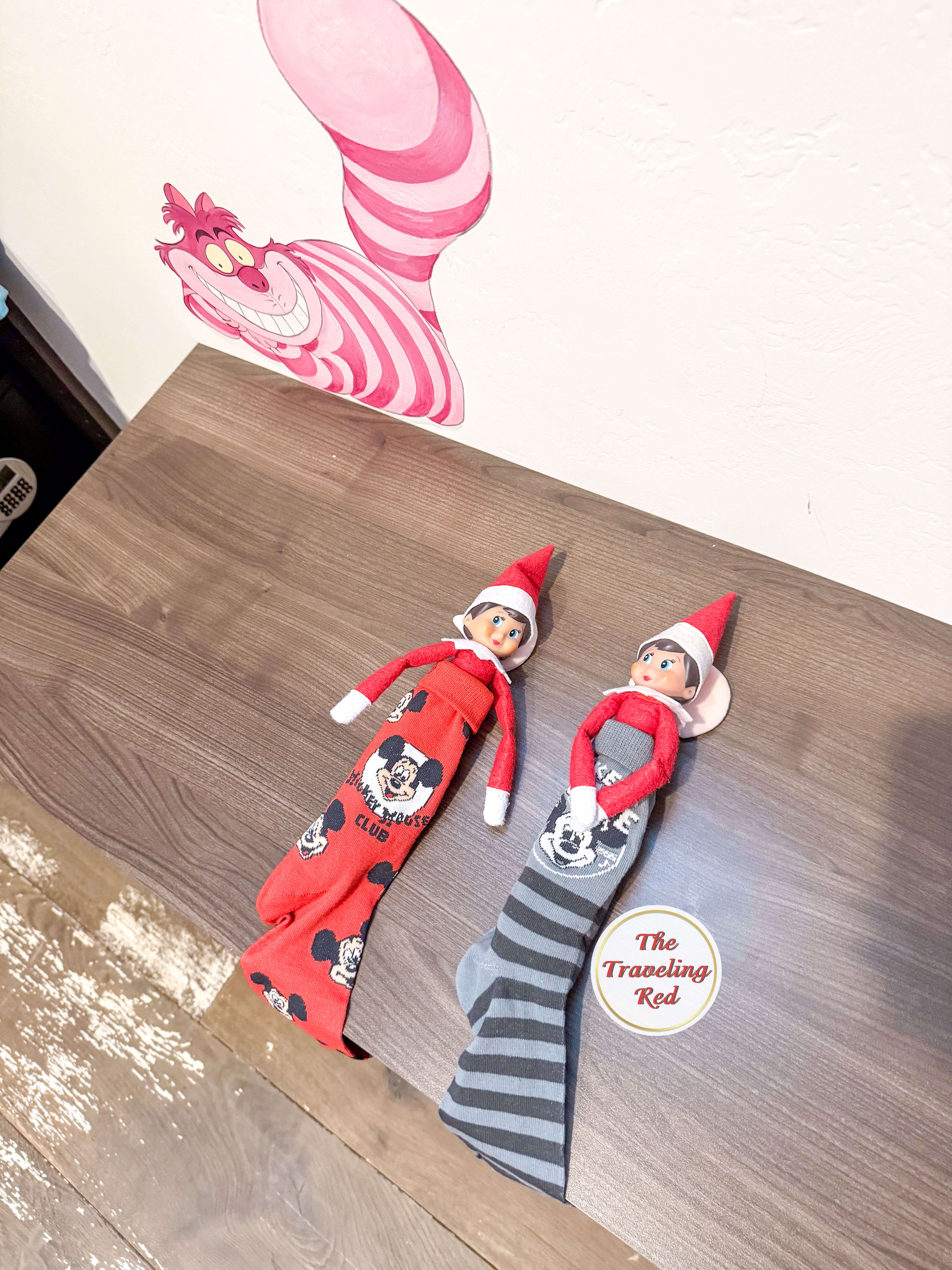 Elf on the Shelf Ideas: Elf is with another elf friend having a sleepover in adult tall socks. They're using the socks as sleepingbags. Over 100 easy and quick elf on the shelf ideas that are fun. By The Traveling Red
