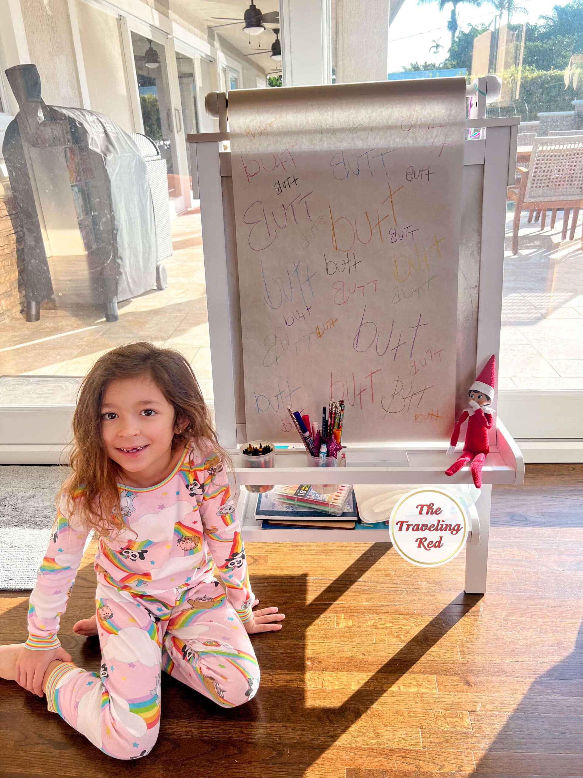 Elf on the Shelf Ideas: Elf used her easel and crayons to write the word butt everywhere. Over 100 easy and quick elf on the shelf ideas that are fun. By The Traveling Red