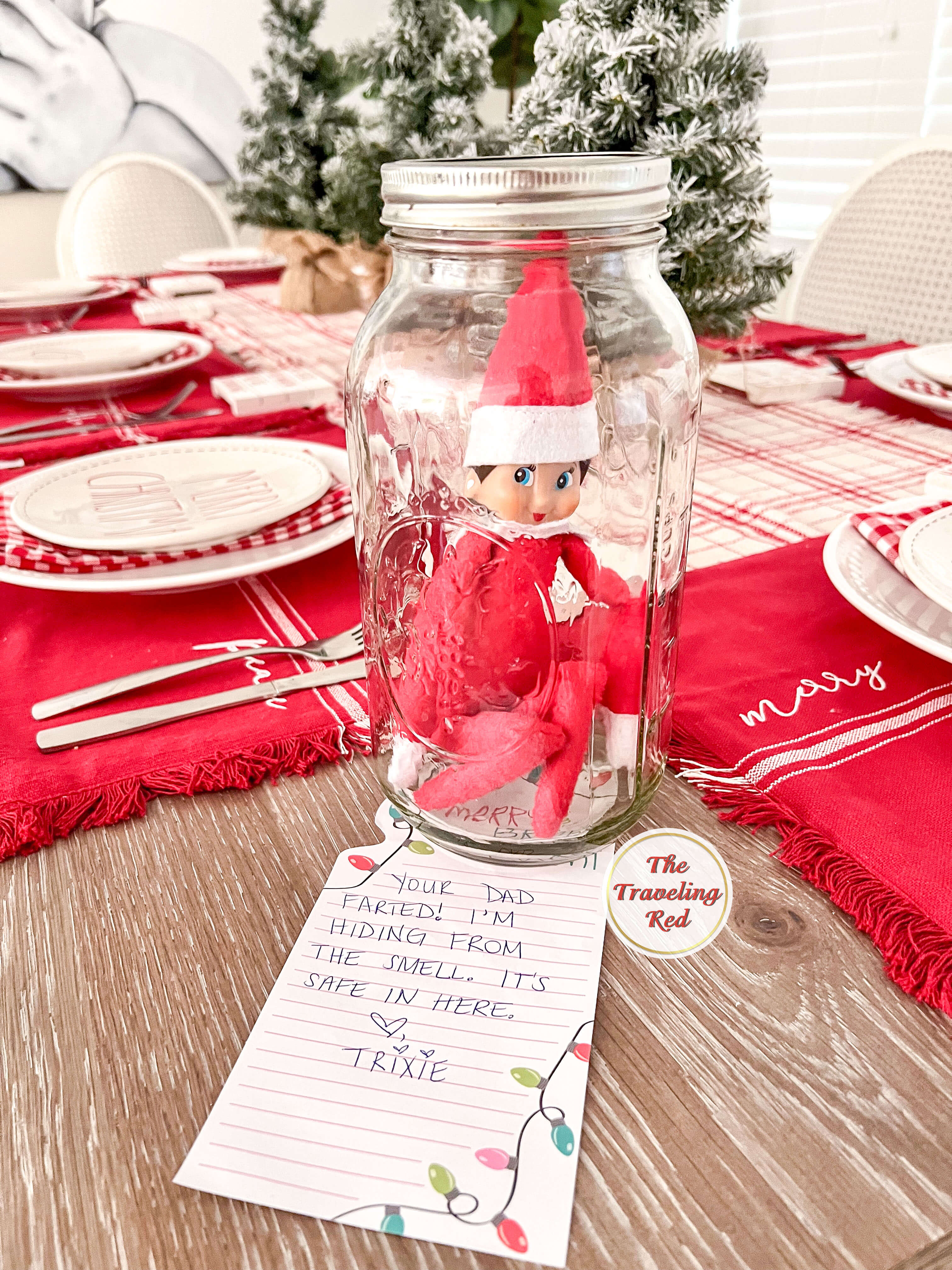 Elf on the Shelf Ideas: Elf is hiding in a mason jar because she is hiding from the smell of dad's fart. The note says "your dad farted. I'm hiding from the smell. It's safe in here." Over 100 easy and quick elf on the shelf ideas that are fun. By The Traveling Red