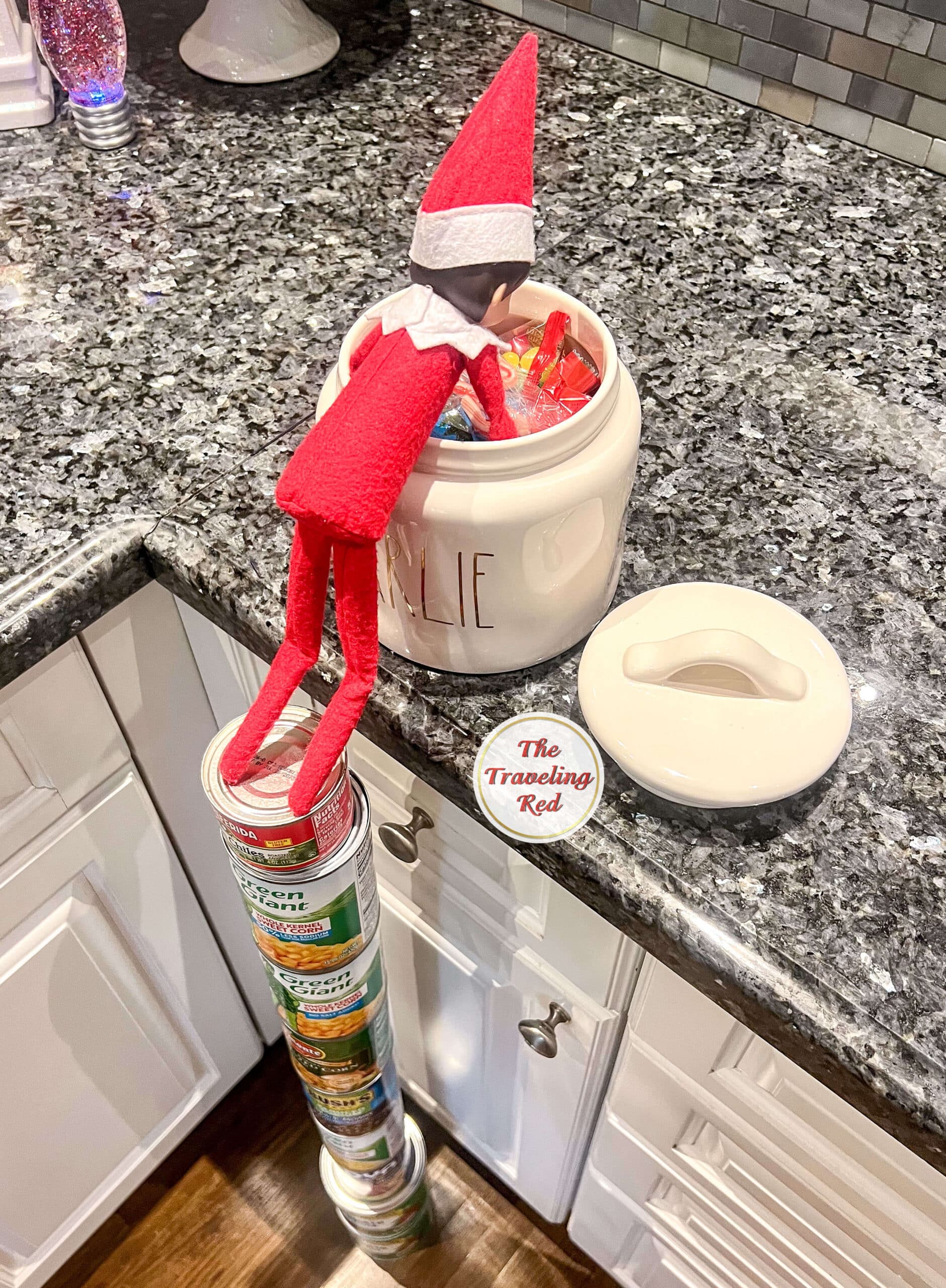 Elf on the Shelf Ideas: Elf made a tower with cans and climbed to the top to get into the open candy jar. Over 100 easy and quick elf on the shelf ideas that are fun. By The Traveling Red