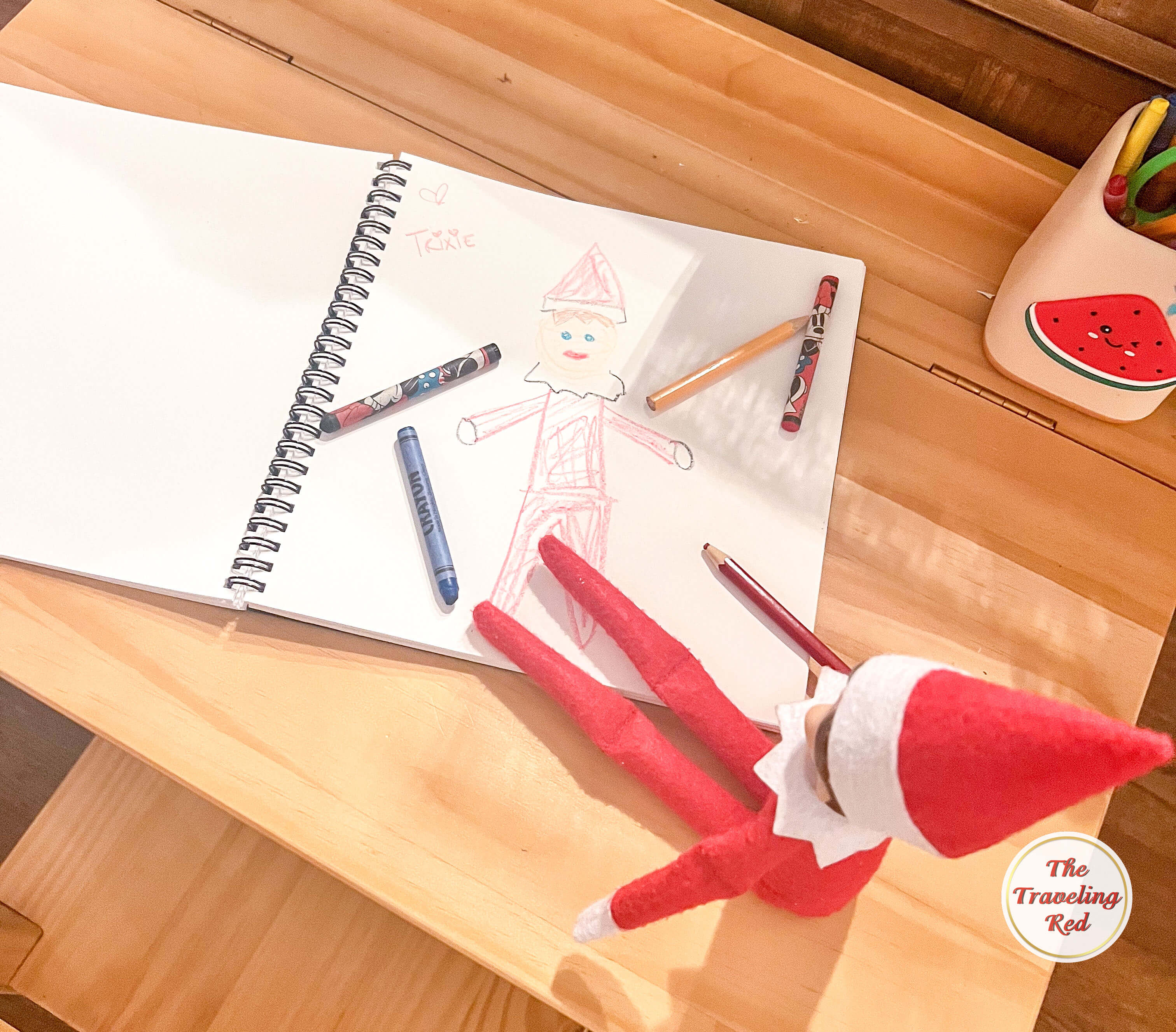 Elf on the Shelf Ideas: Elf drew a self portrait on a sketch pad and called it an Elf Portrait. Over 100 easy and quick elf on the shelf ideas that are fun. By The Traveling Red