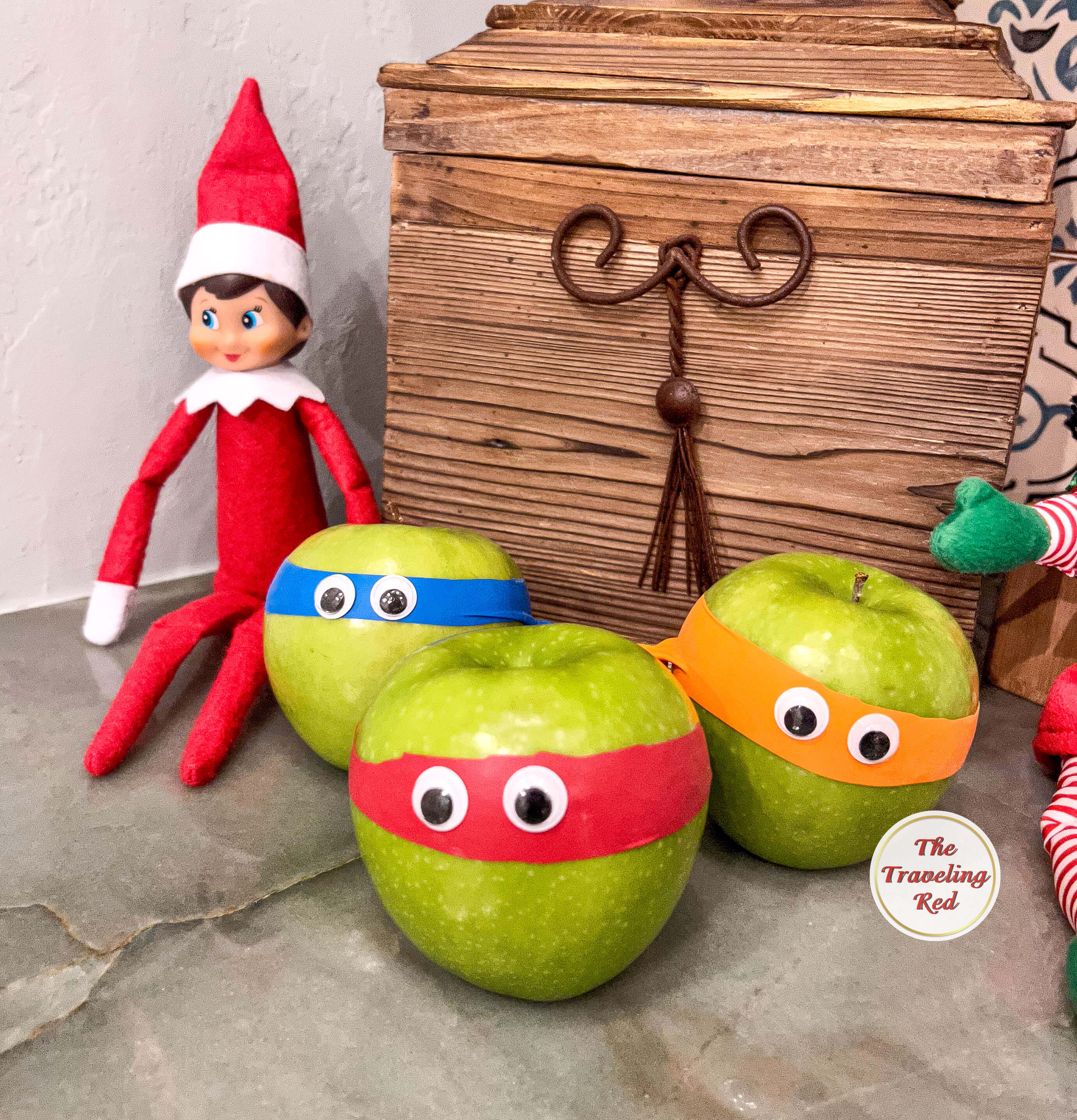 Elf on the Shelf Ideas: Elf turned 3 green apples into ninja turtles using balloons that were cut up and googly eyes. Over 100 easy and quick elf on the shelf ideas that are fun. By The Traveling Red