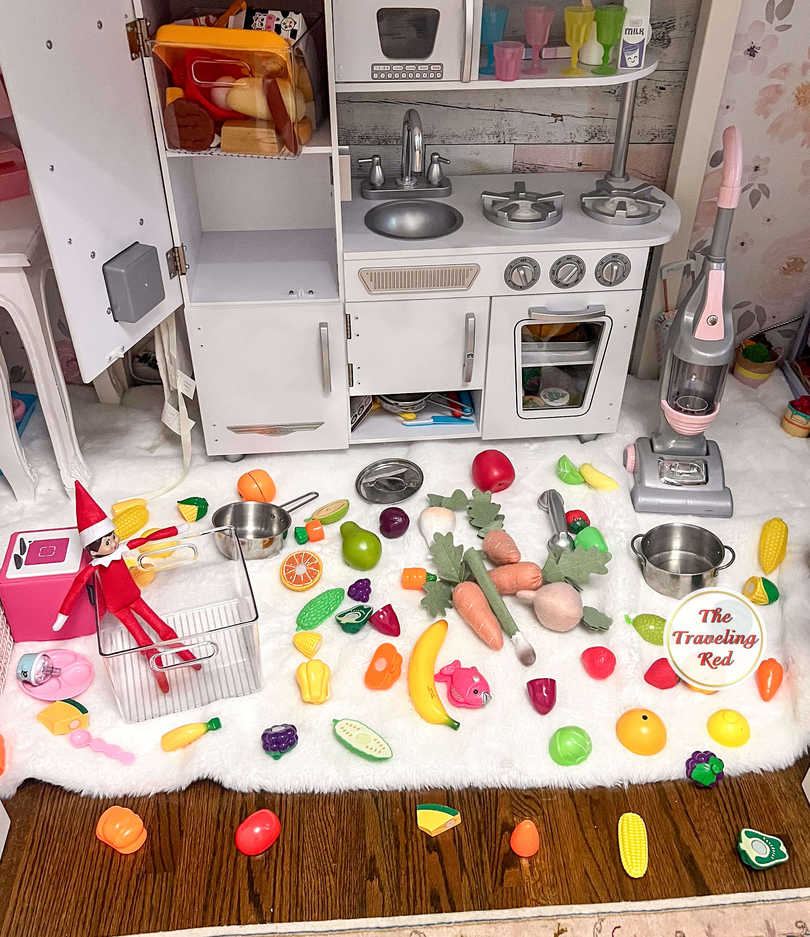 Elf on the Shelf Ideas: Elf made a mess by removing all of the food items from the little kitchen and is inside the container that housed all the food items. Over 100 easy and quick elf on the shelf ideas that are fun. By The Traveling Red