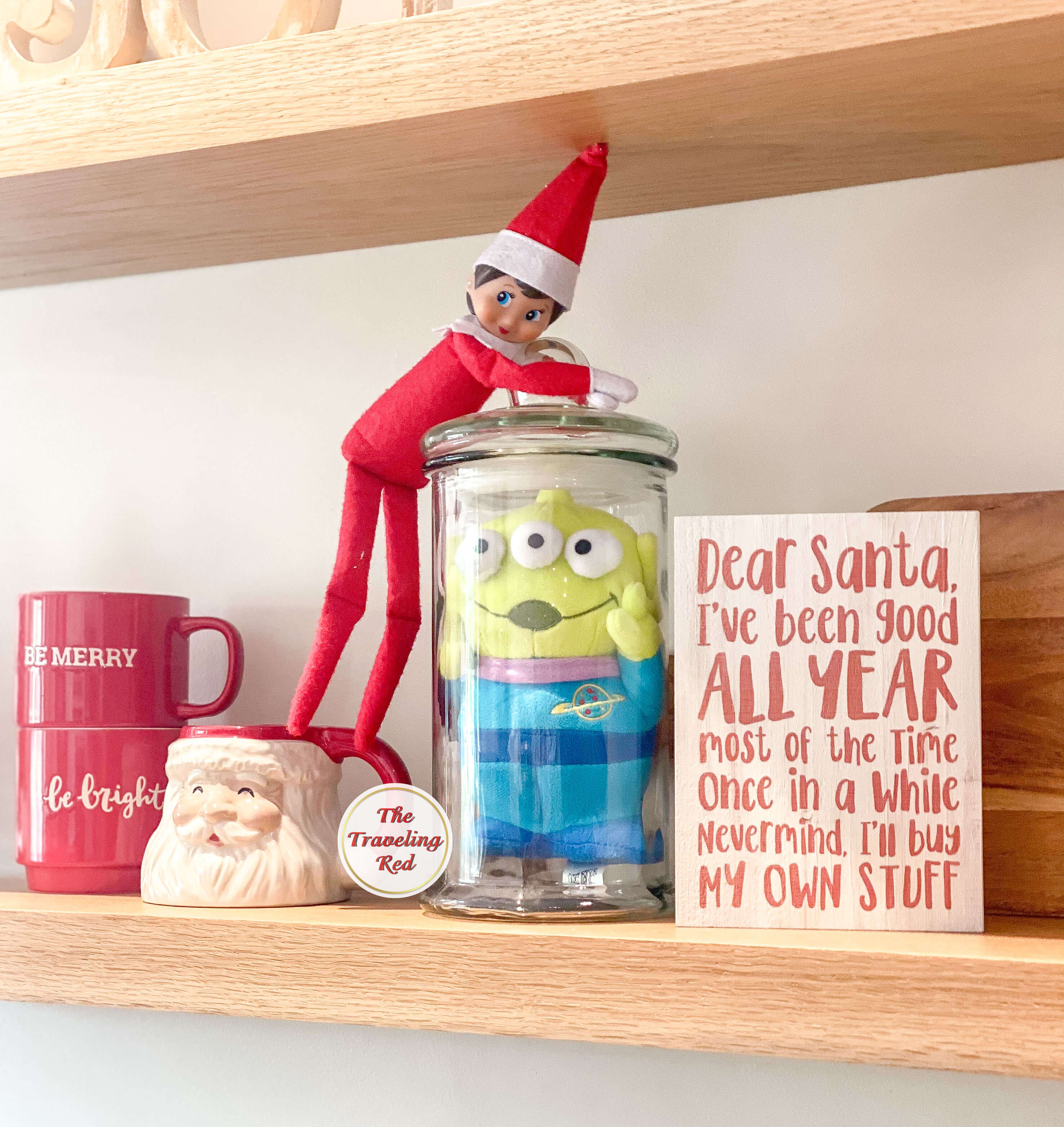 Elf on the Shelf Ideas: Elf captured a toy in a clear jar. Over 100 easy and quick elf on the shelf ideas that are fun. By The Traveling Red