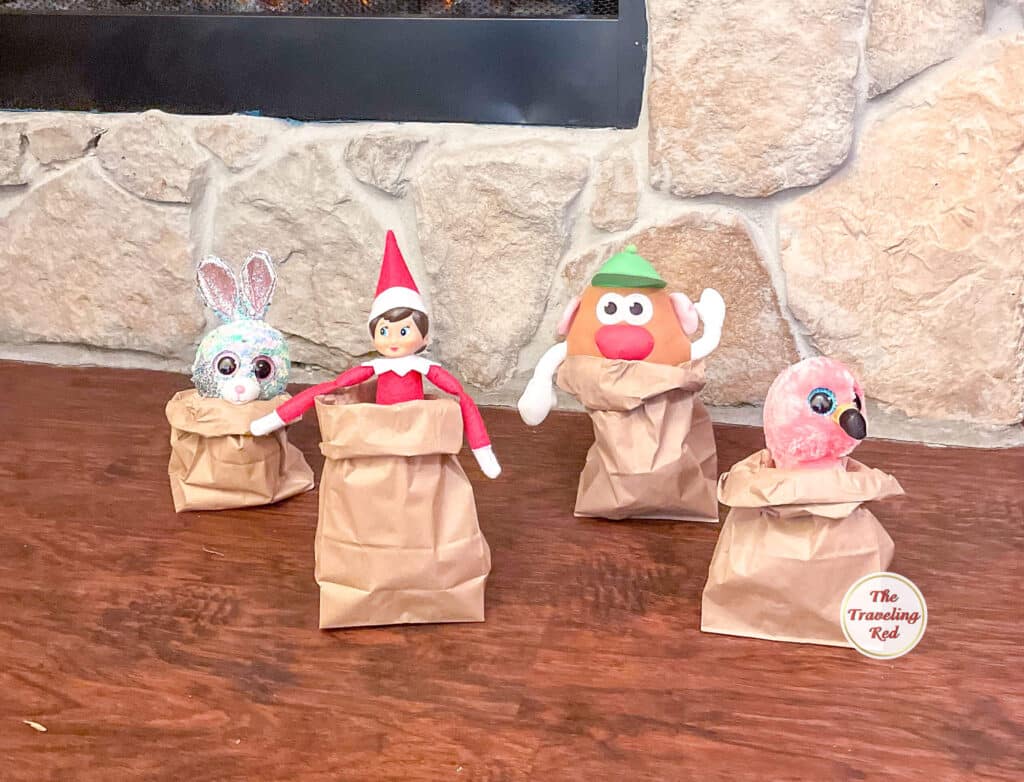 Elf on the Shelf Ideas: Elf is having a potato sack race with some toy friends using brown paper bags. Over 100 easy and quick elf on the shelf ideas that are fun. By The Traveling Red