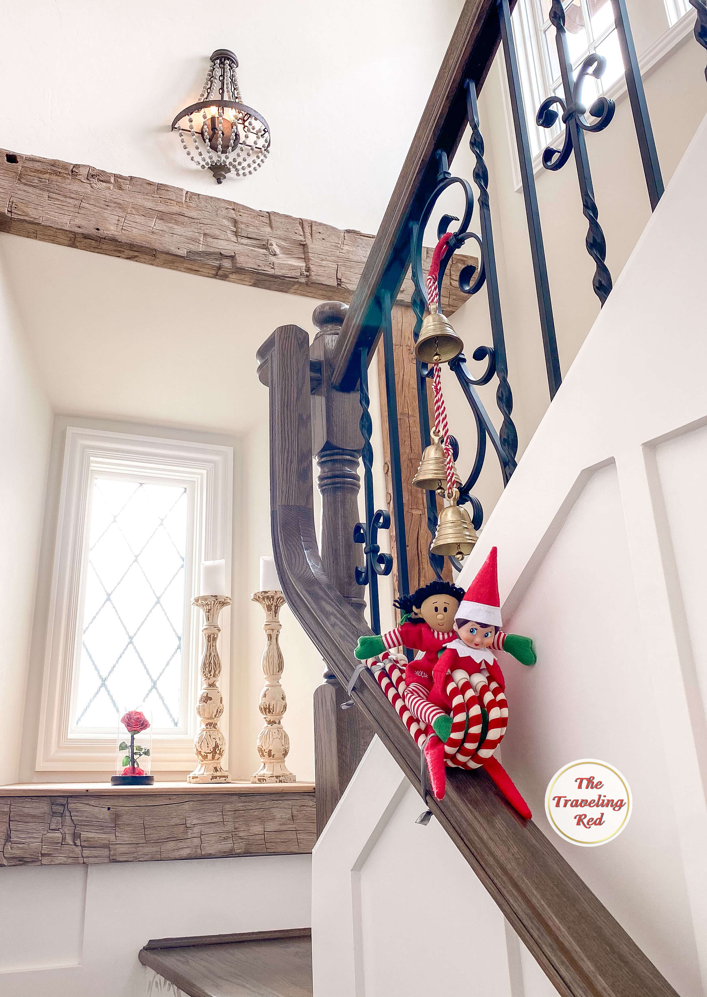 Elf on the Shelf Ideas: Elf is going down the staircase railing with a friend on a sled made of candy canes attached together. Over 100 easy and quick elf on the shelf ideas that are fun. By The Traveling Red