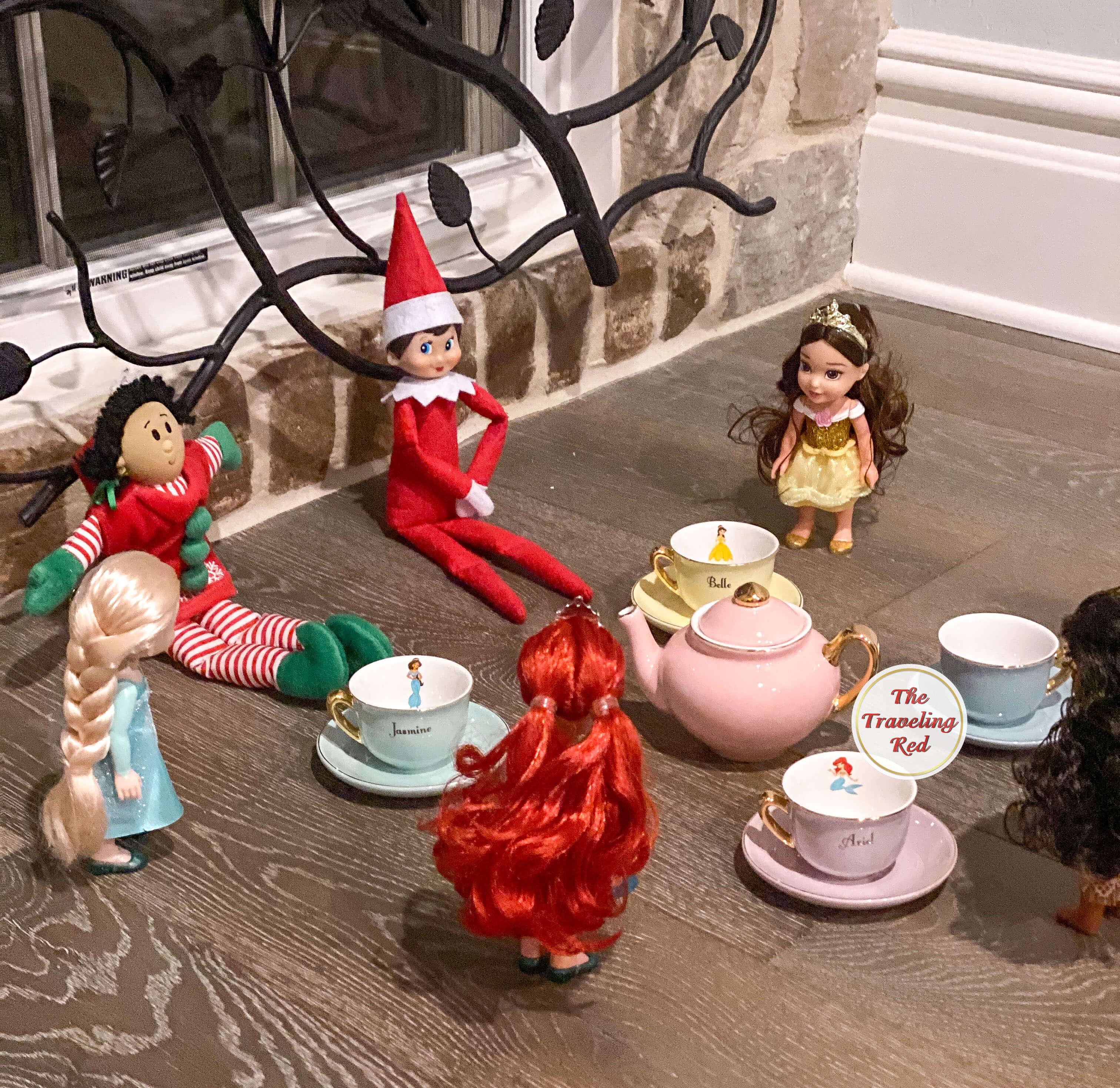 Elf on the Shelf Ideas: Elf is having a tea party with some little dolls using a tea set. Over 100 easy and quick elf on the shelf ideas that are fun. By The Traveling Red