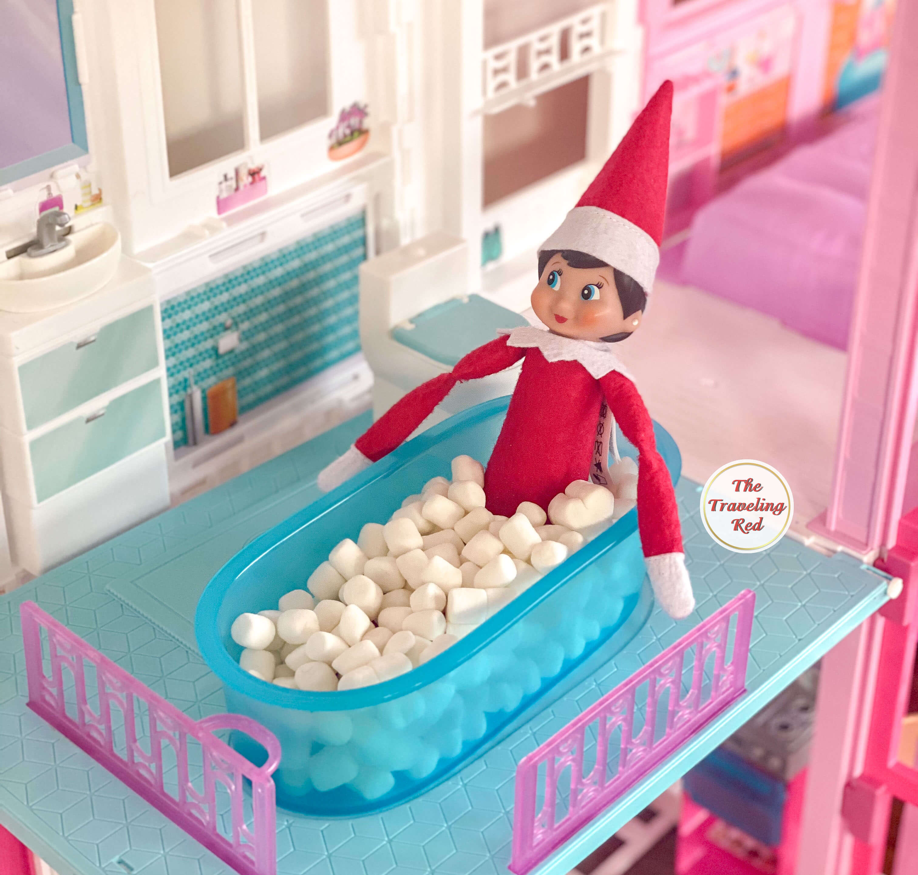 Elf on the Shelf Ideas: Elf having a mini marshmallow bubble bath in the barbie house bathtub. Over 100 easy and quick elf on the shelf ideas that are fun. By The Traveling Red