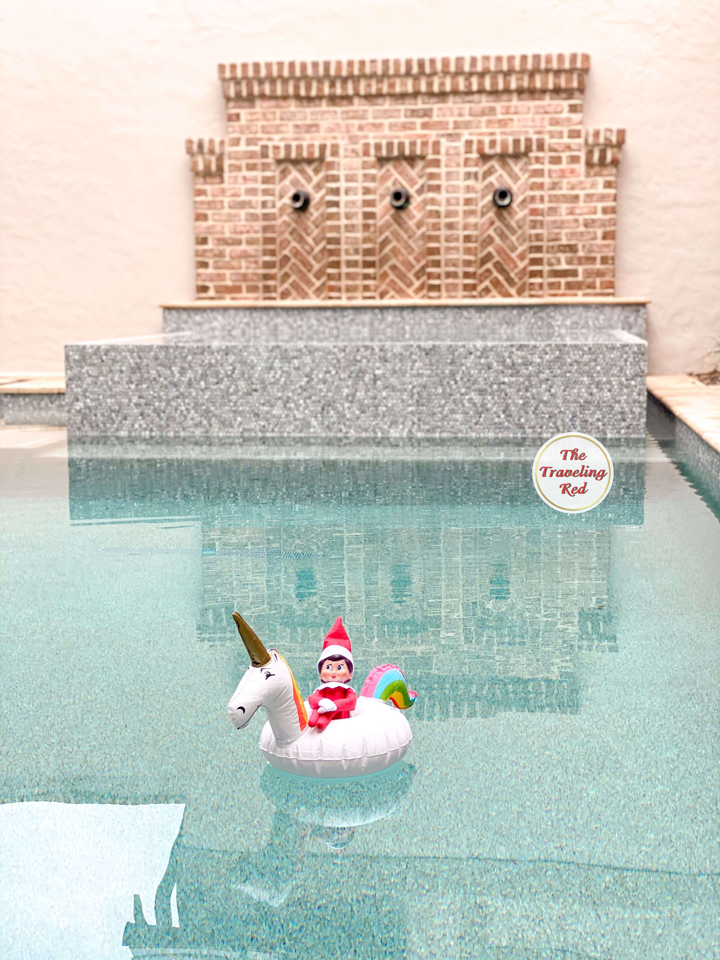 Elf on the Shelf Ideas: Elf in on a floaty in the pool. The floaty is a unicorn drink floaty. Over 100 easy and quick elf on the shelf ideas that are fun. By The Traveling Red