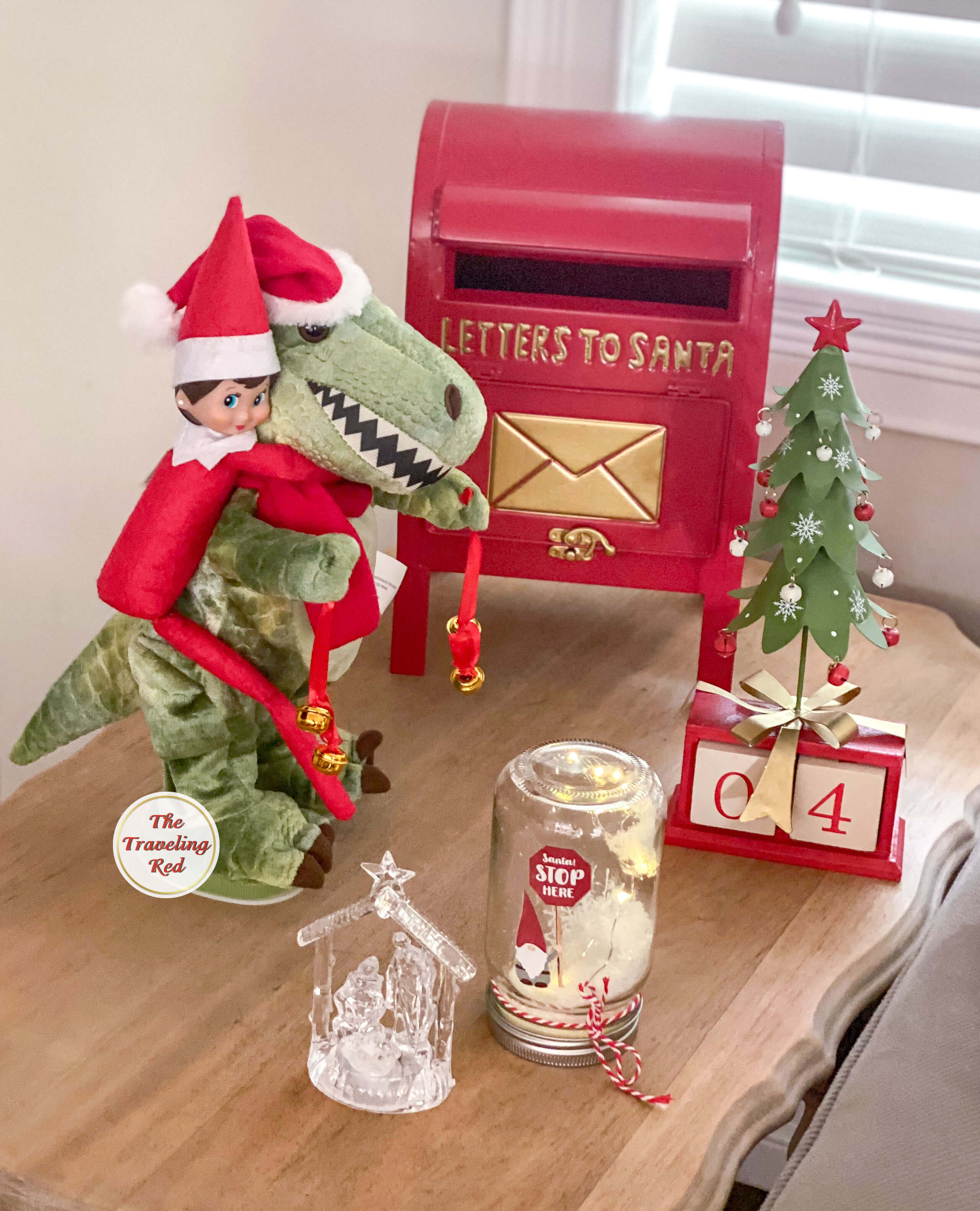 Elf on the Shelf Ideas: Elf riding on the back of a Christmas dinosaur decoration. Over 100 easy and quick elf on the shelf ideas that are fun. By The Traveling Red